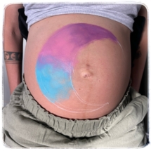 Close up of a beautifully painted baby bump, featuring moon design with delicate details. unique pregnancy belly painting in Tauranga