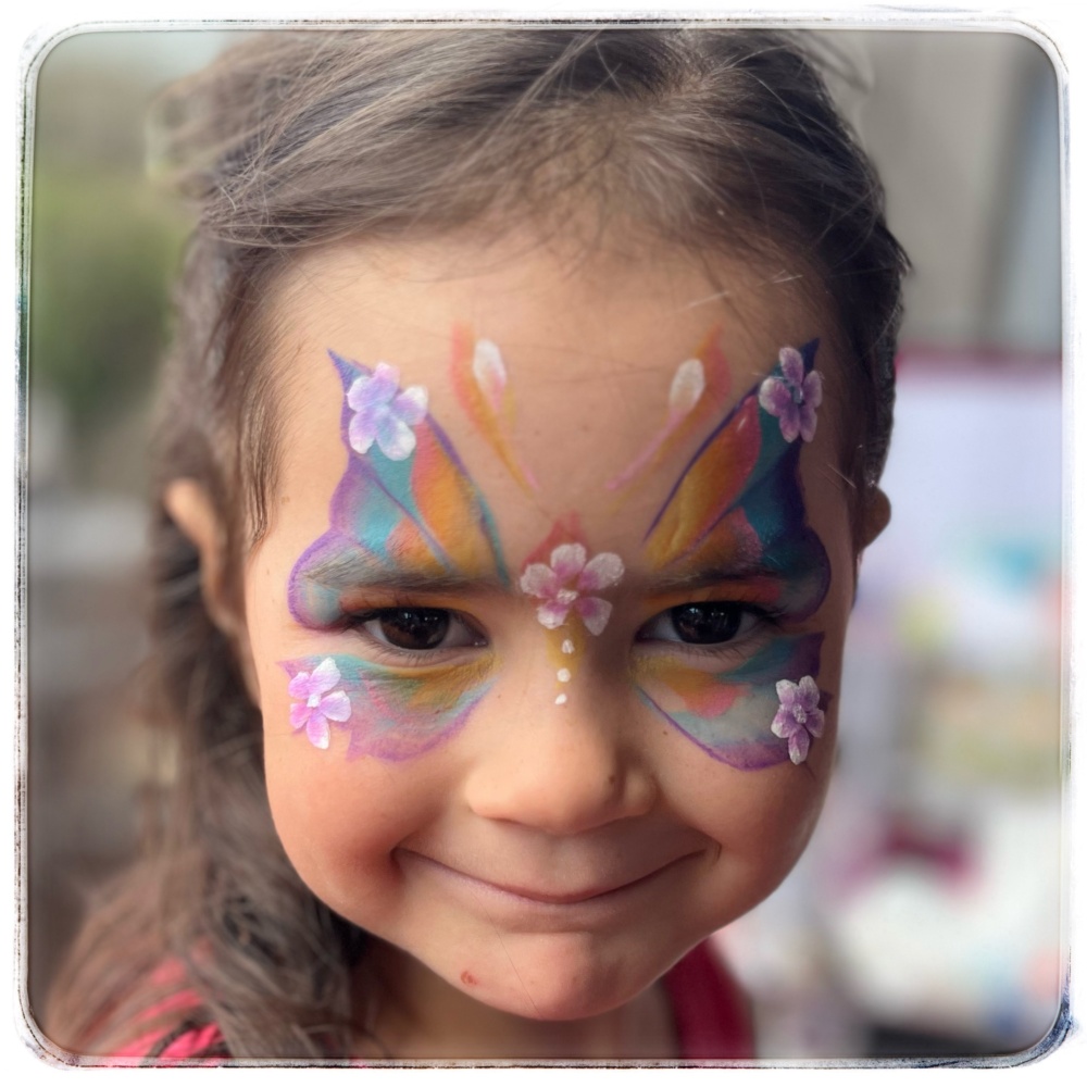 Beutiful face painting, colourful butterfly with flowers on a girl