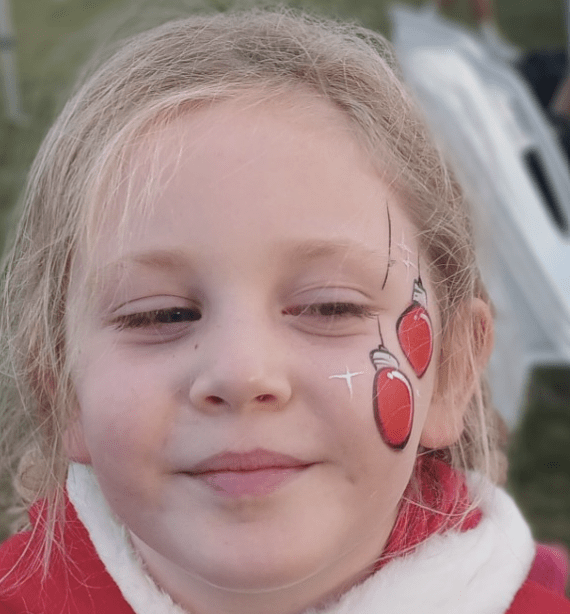Christmas ornament face paint on a girl, that makes her smile.
