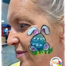 Child with Easter egg face paint and bunny ears design at a Tauranga event