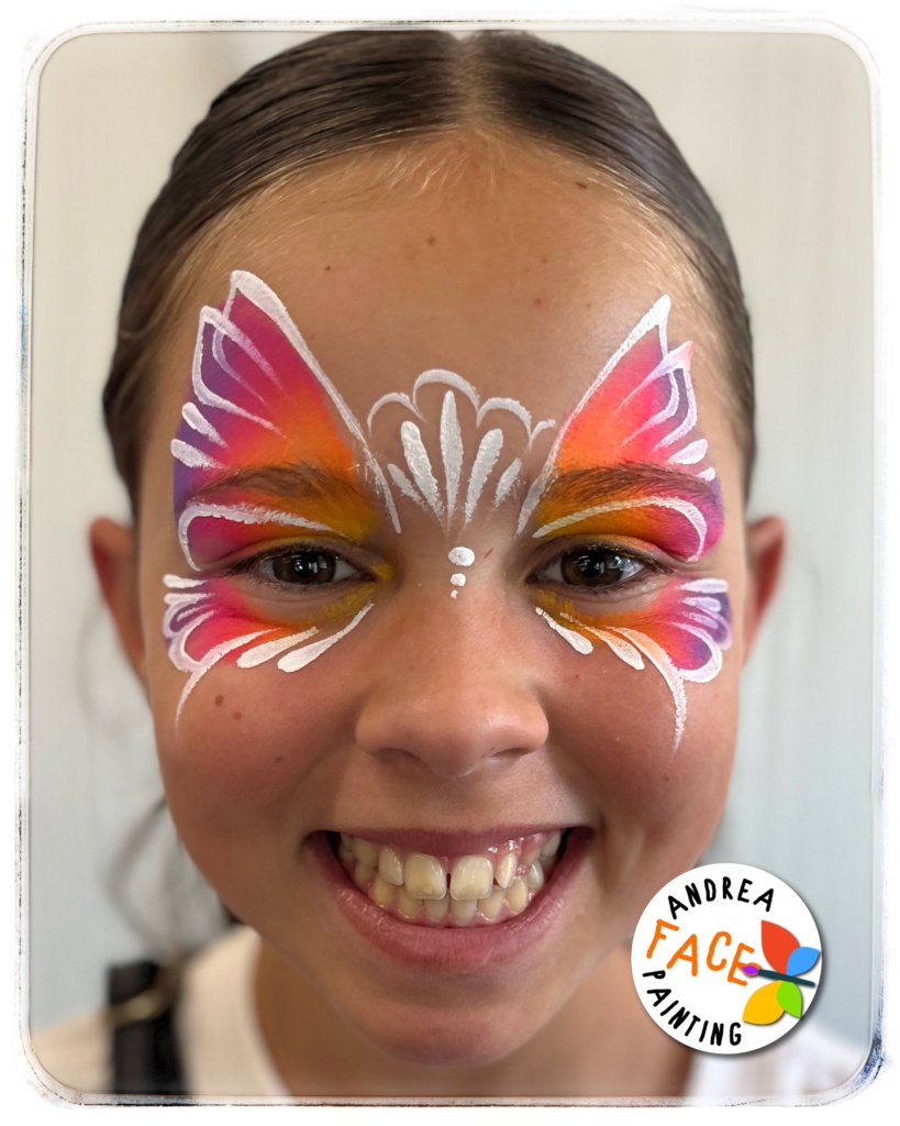 Face painter Andrea creating beautiful designs for children at a community event inside Tauranga Library, with kids enjoying the playful atmosphere.